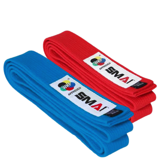 Two neatly folded red and blue karate belts against a white background. The belts feature a clean, bright red and blue color and appears to be made of a thick, woven textile, indicative of good quality material. Prominently displayed on one end of the belt is a rectangular label with the SMAI logo and the text "WKF APPROVED", signifying its suitability for use in World Karate Federation sanctioned events.