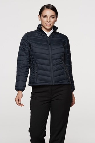 Front view of a model wearing a black Women's Puffer Vest, styled with a white shirt underneath, showcasing a practical and stylish design for outdoor activities.